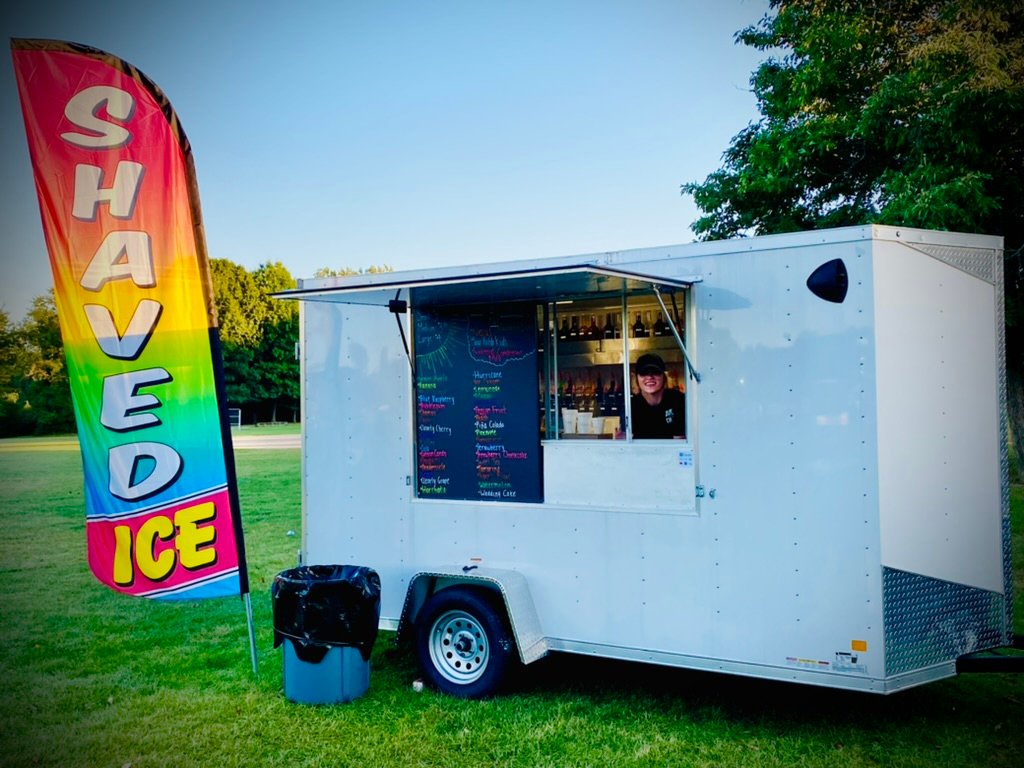 Summer Snow trailer setup next to a shaved ice feather flag